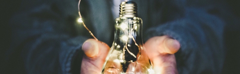 Ampoule illuminée dans les mains de quelqu'un