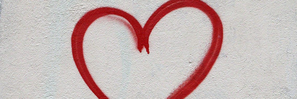 Coeur rouge dessiné sur un mur de béton blanc