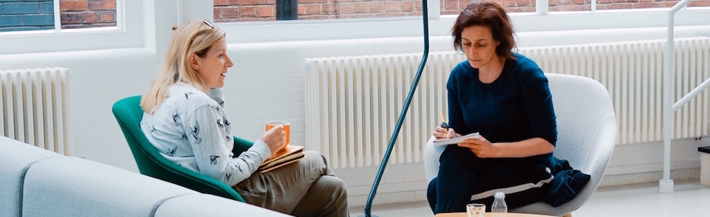 Deux femmes assises dans une aire de pause en réunion