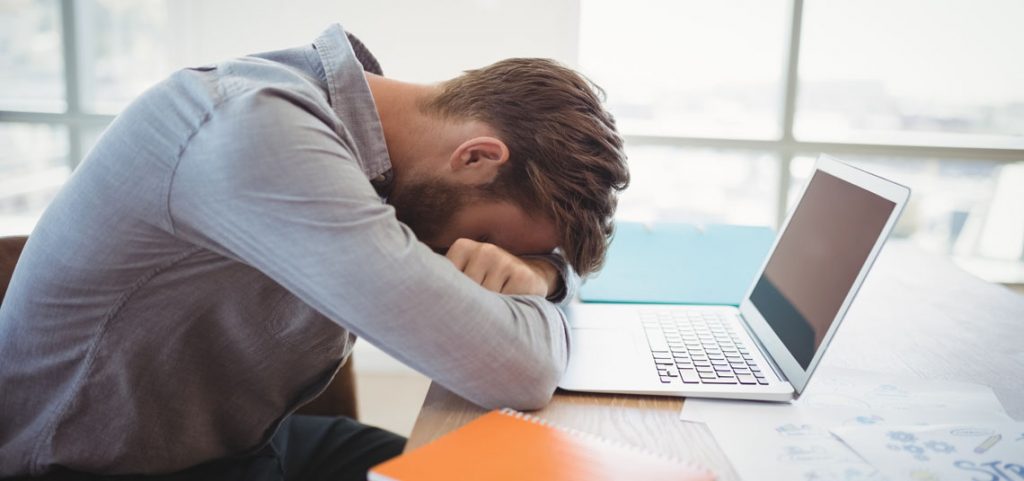 Gestionnaire épuisé la tête sur son ordinateur