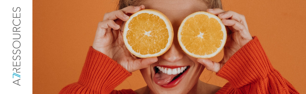 Femme qui tient des tranches d'orange devant ses yeux